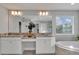 Bathroom featuring a large mirror, double sinks, soaking tub, and updated vanity at 17845 Cortes Creek Blvd, Spring Hill, FL 34610