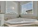Bright bathroom featuring a tiled soaking tub next to windows at 17845 Cortes Creek Blvd, Spring Hill, FL 34610