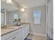 Well-lit bathroom features double sinks with granite counters and white cabinets at 17845 Cortes Creek Blvd, Spring Hill, FL 34610