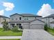 Inviting two-story home with a three-car garage and lush green lawn at 17845 Cortes Creek Blvd, Spring Hill, FL 34610