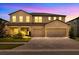Warmly lit two-story home featuring a three-car garage and a welcoming front entrance at 17845 Cortes Creek Blvd, Spring Hill, FL 34610