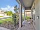 Inviting front porch with brick flooring, two chairs and landscaped yard at 17845 Cortes Creek Blvd, Spring Hill, FL 34610