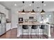 Bright kitchen features a granite island with bar stool seating and modern pendant lighting at 17845 Cortes Creek Blvd, Spring Hill, FL 34610