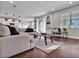 Bright living room with dark hardwood floors, large windows, and stylish decor leading into an open concept kitchen at 17845 Cortes Creek Blvd, Spring Hill, FL 34610