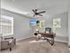 Light-filled office with a modern desk, ceiling fan, and comfortable seating at 17845 Cortes Creek Blvd, Spring Hill, FL 34610