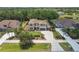 Aerial view of a home with well-manicured lawn, mature trees, and circular driveway at 17914 Bramshot Pl, Lutz, FL 33559