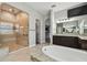 This bathroom has a walk in shower, large soaking tub with jets, and dark wooden cabinets at 17914 Bramshot Pl, Lutz, FL 33559