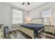 Bedroom with ceiling fan, ensuite windows, and hardwood floors at 17914 Bramshot Pl, Lutz, FL 33559