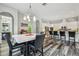 The modern dining area features a marble table, leather high-back chairs, and an elegant chandelier at 17914 Bramshot Pl, Lutz, FL 33559