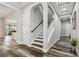 Elegant foyer with wood-look flooring, featuring arched doorways, staircase, and neutral decor at 17914 Bramshot Pl, Lutz, FL 33559