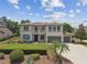 Attractive two-story home features a three-car garage, neat lawn, and elegant blue shutters at 17914 Bramshot Pl, Lutz, FL 33559