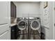 Laundry room with modern appliances, storage, and a utility sink at 17914 Bramshot Pl, Lutz, FL 33559