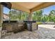 Fully equipped outdoor kitchen with granite counters, stainless steel grill, and screened enclosure at 17914 Bramshot Pl, Lutz, FL 33559