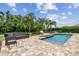 Relaxing backyard oasis featuring a sparkling pool, stylish furniture, and lush landscaping at 17914 Bramshot Pl, Lutz, FL 33559