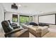 Home theater room with projector, large screen, comfortable seating, and access to outdoor balcony at 17914 Bramshot Pl, Lutz, FL 33559