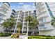 Exterior of the building with multiple balconies and beautiful, mature landscaping at 17980 Gulf Blvd # 505, Redington Shores, FL 33708