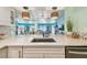 Stylish kitchen with white cabinets, quartz countertops, mosaic tile backsplash and stainless appliances at 17980 Gulf Blvd # 505, Redington Shores, FL 33708