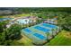 Expansive aerial view of community amenities featuring a pool, clubhouse, and tennis courts at 19247 Otters Wick Way, Land O Lakes, FL 34638