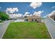 Spacious backyard with green lawn, white picket fence, and patio area at 19247 Otters Wick Way, Land O Lakes, FL 34638