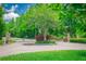 Gated community entrance featuring stone pillars, lush landscaping, and secure access for residents' privacy and peace of mind at 19247 Otters Wick Way, Land O Lakes, FL 34638