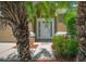 Close-up of the front entrance with a white door, palm trees and attractive landscaping at 19247 Otters Wick Way, Land O Lakes, FL 34638