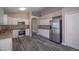 Well-lit kitchen with modern stainless steel appliances, granite counters and dark wood-look flooring at 19247 Otters Wick Way, Land O Lakes, FL 34638