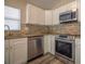 Bright kitchen featuring stainless steel appliances, light-colored cabinets, and granite countertops at 19247 Otters Wick Way, Land O Lakes, FL 34638
