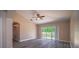 Living room with hardwood floors, a ceiling fan, and sliding glass doors to the backyard at 19247 Otters Wick Way, Land O Lakes, FL 34638