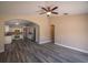 Open-concept living room with wood floors, ceiling fan, and open to the kitchen at 19247 Otters Wick Way, Land O Lakes, FL 34638