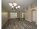 Open-concept living area featuring a chandelier, neutral walls, and wood flooring at 19247 Otters Wick Way, Land O Lakes, FL 34638