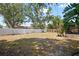 Spacious backyard enclosed with a white fence, mature trees, and greenery, offering privacy and an outdoor space at 2048 64Th S Ave, St Petersburg, FL 33712
