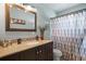 Stylish bathroom with a dark wood vanity, granite countertop, decorative mirror and tiled shower/tub at 2048 64Th S Ave, St Petersburg, FL 33712