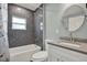 Charming bathroom featuring a tub with dark gray tiled walls and a modern vanity at 2107 W Carmen St, Tampa, FL 33606