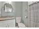Well-lit bathroom with a granite countertop, vanity, and neatly organized shower at 2107 W Carmen St, Tampa, FL 33606