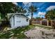 Exterior of home with white siding, gravel yard, tropical trees, and backyard storage shed at 2443 2Nd S Ave, St Petersburg, FL 33712