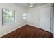 Bright bedroom featuring hardwood floors, two windows, and a white ceiling fan at 2443 2Nd S Ave, St Petersburg, FL 33712