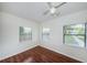 Bedroom featuring hardwood floors, three windows with blinds and a white ceiling fan at 2443 2Nd S Ave, St Petersburg, FL 33712