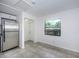 Kitchen area with stainless steel fridge, gray tiled floor, and a window with view to the outside at 2443 2Nd S Ave, St Petersburg, FL 33712