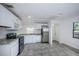 Bright kitchen with white cabinets, stainless steel appliances, granite countertops, and gray tiled floor at 2443 2Nd S Ave, St Petersburg, FL 33712