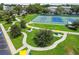 Aerial view of the community park with walking paths, mature trees, picnic tables, and tennis courts at 2468 Florentine Way # 26, Clearwater, FL 33763