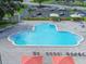 Aerial view of the community pool surrounded by lounge chairs and red umbrellas at 2468 Florentine Way # 26, Clearwater, FL 33763