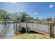 Scenic view of a pond with a wooden dock and lush green surroundings at 2468 Florentine Way # 26, Clearwater, FL 33763
