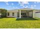 Backyard with a screened lanai and lush lawn under a bright sky at 25332 Lexington Oaks Blvd, Wesley Chapel, FL 33544