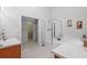 Spacious bathroom with double vanities, a walk-in closet, and a glass-enclosed shower at 25332 Lexington Oaks Blvd, Wesley Chapel, FL 33544