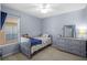 Bedroom with a twin bed, dresser, carpeted floor, and natural light at 25332 Lexington Oaks Blvd, Wesley Chapel, FL 33544