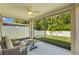 Enclosed lanai with comfortable seating, ceiling fan, and views of the lush backyard at 25332 Lexington Oaks Blvd, Wesley Chapel, FL 33544