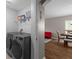 Convenient laundry area with modern washer and dryer units, shelving, and easy access to other living areas at 25332 Lexington Oaks Blvd, Wesley Chapel, FL 33544