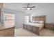 Bright primary bedroom with decorative bed frame, carpet flooring, and two windows at 25332 Lexington Oaks Blvd, Wesley Chapel, FL 33544