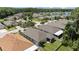 Birds-eye view of homes displaying roofs, lawns, and a community pond with lush trees at 25332 Lexington Oaks Blvd, Wesley Chapel, FL 33544