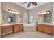 Bright bathroom with dual vanities, a garden tub under a window and beach decor accents at 25942 Risen Star Dr, Wesley Chapel, FL 33544